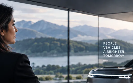 Looking out of a glass-walled studio across a lake towards mountains, with a Range Rover parked outside